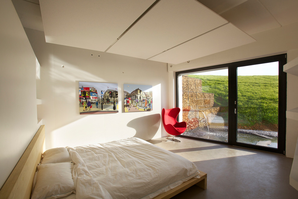 Inspiration för ett funkis sovrum, med beige väggar och betonggolv