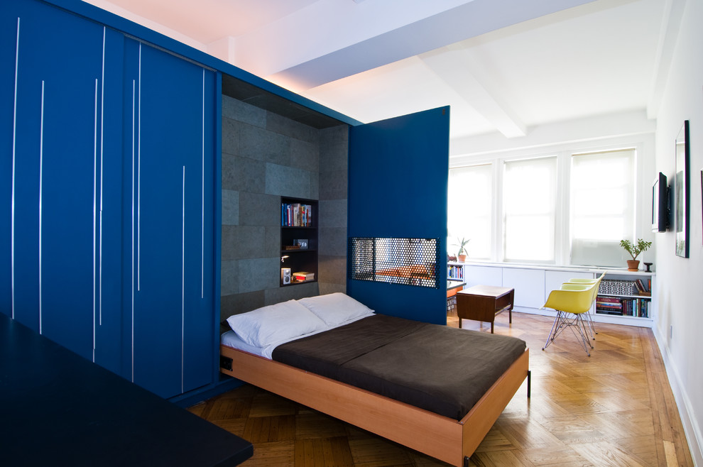 Example of a trendy medium tone wood floor bedroom design in New York with blue walls