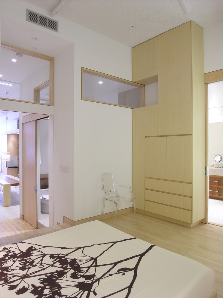 Cette image montre une chambre design avec un mur blanc et parquet clair.