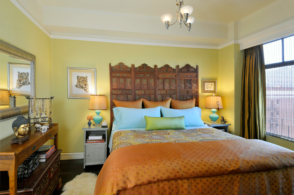 Cette photo montre une chambre avec un mur jaune et parquet foncé.