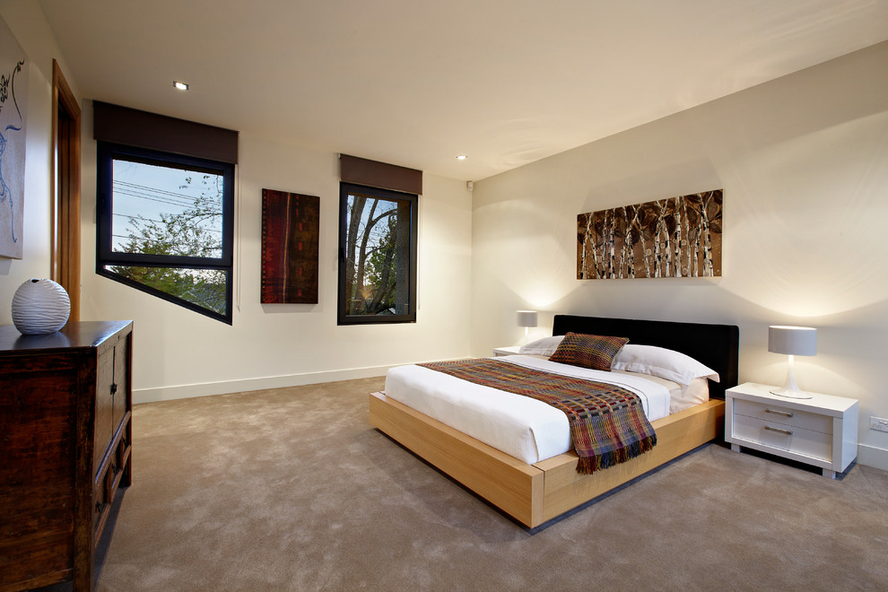 Immagine di una grande camera da letto minimal con pareti beige e moquette
