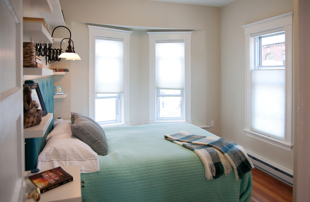 Modelo de dormitorio principal retro pequeño con paredes grises y suelo de madera en tonos medios