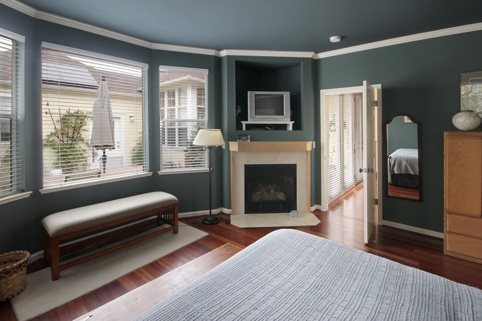 Example of a large classic master dark wood floor and brown floor bedroom design in Other with gray walls, a standard fireplace and a tile fireplace