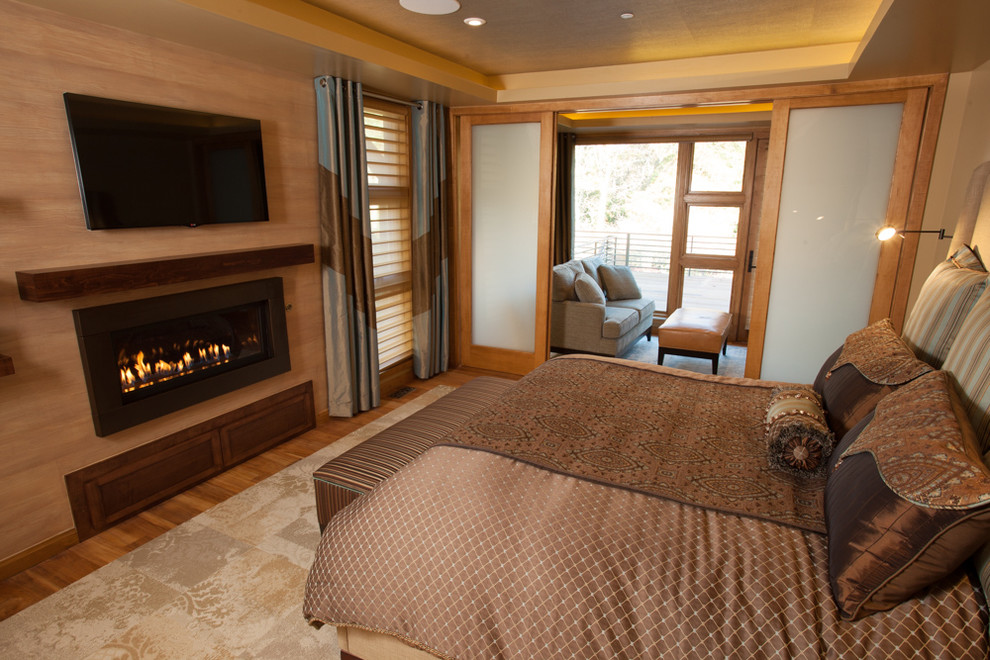 На фото: хозяйская спальня среднего размера в стиле неоклассика (современная классика) с бежевыми стенами, светлым паркетным полом, стандартным камином и фасадом камина из дерева с