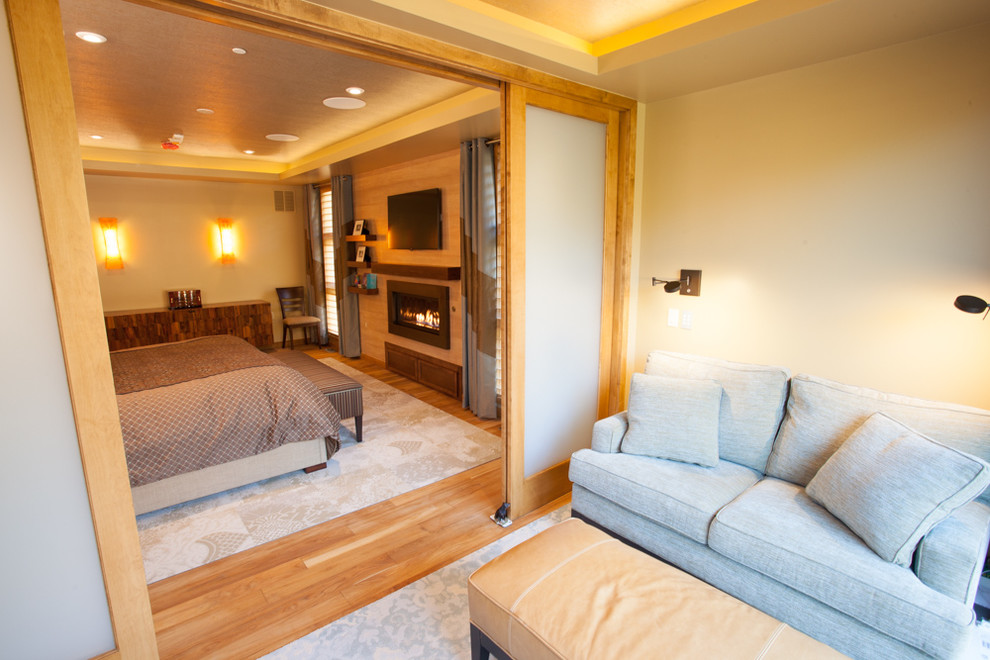 Идея дизайна: хозяйская спальня среднего размера в стиле неоклассика (современная классика) с бежевыми стенами, светлым паркетным полом, стандартным камином и фасадом камина из дерева