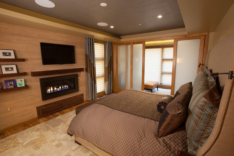 Diseño de dormitorio principal clásico renovado de tamaño medio con paredes beige, suelo de madera clara, todas las chimeneas y marco de chimenea de madera
