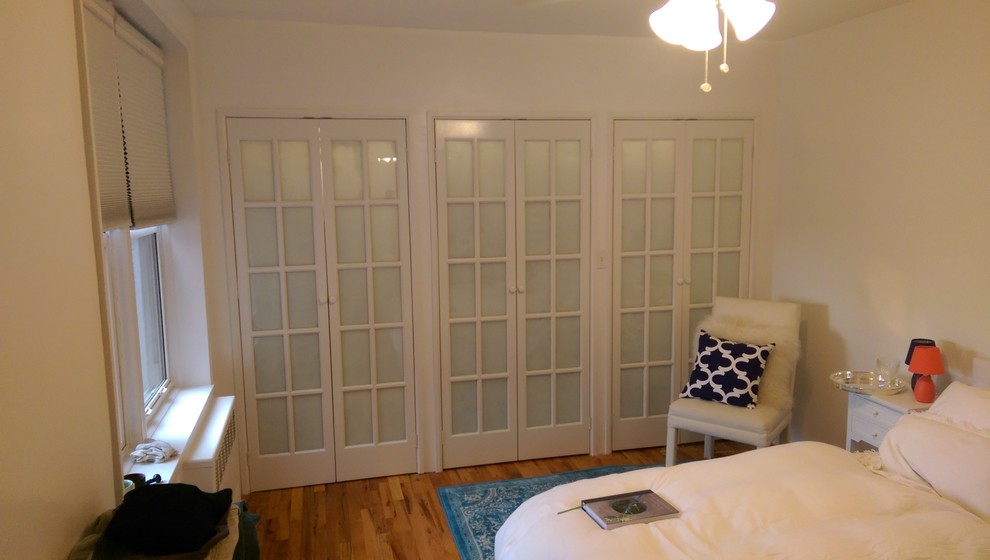 Diseño de habitación de invitados tradicional de tamaño medio sin chimenea con suelo de madera en tonos medios y paredes blancas