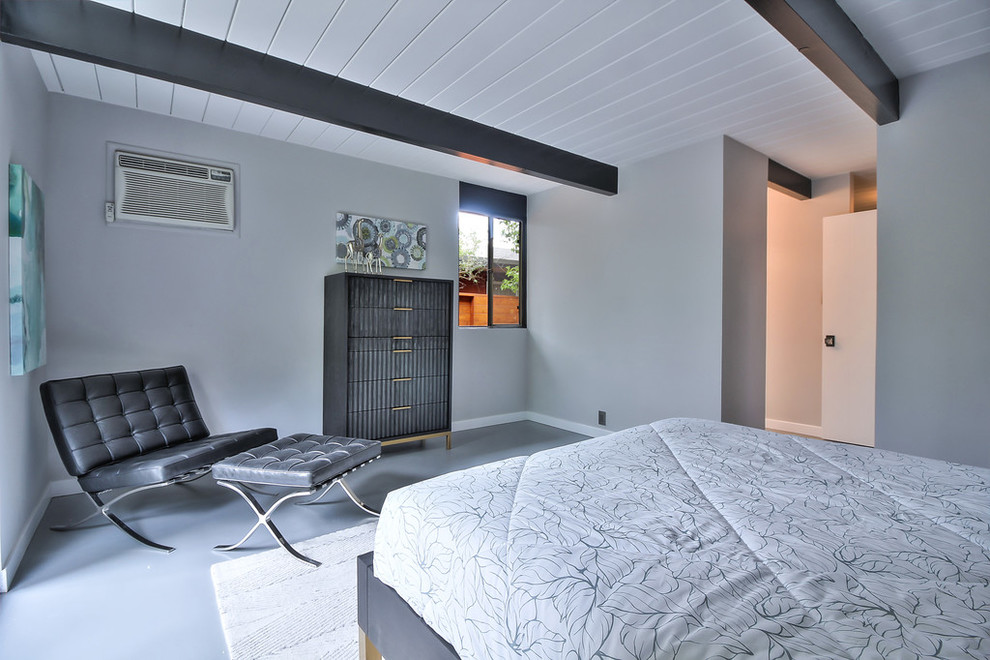 他の地域にある中くらいなミッドセンチュリースタイルのおしゃれな主寝室 (グレーの壁、コンクリートの床、暖炉なし、グレーの床) のインテリア