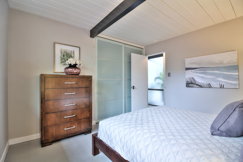 Идея дизайна: гостевая спальня среднего размера, (комната для гостей) в стиле ретро с бежевыми стенами, бетонным полом и серым полом без камина