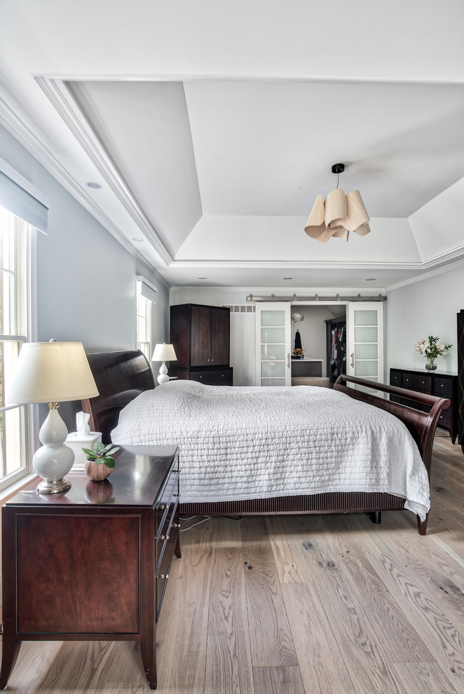 На фото: большая хозяйская спальня в стиле неоклассика (современная классика) с серыми стенами и светлым паркетным полом без камина с