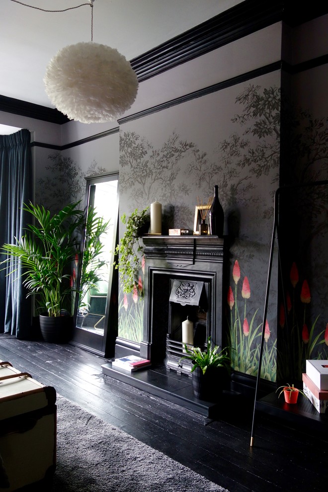 Exemple d'une chambre d'amis éclectique de taille moyenne avec un mur multicolore, parquet peint, une cheminée standard, un manteau de cheminée en métal et un sol noir.