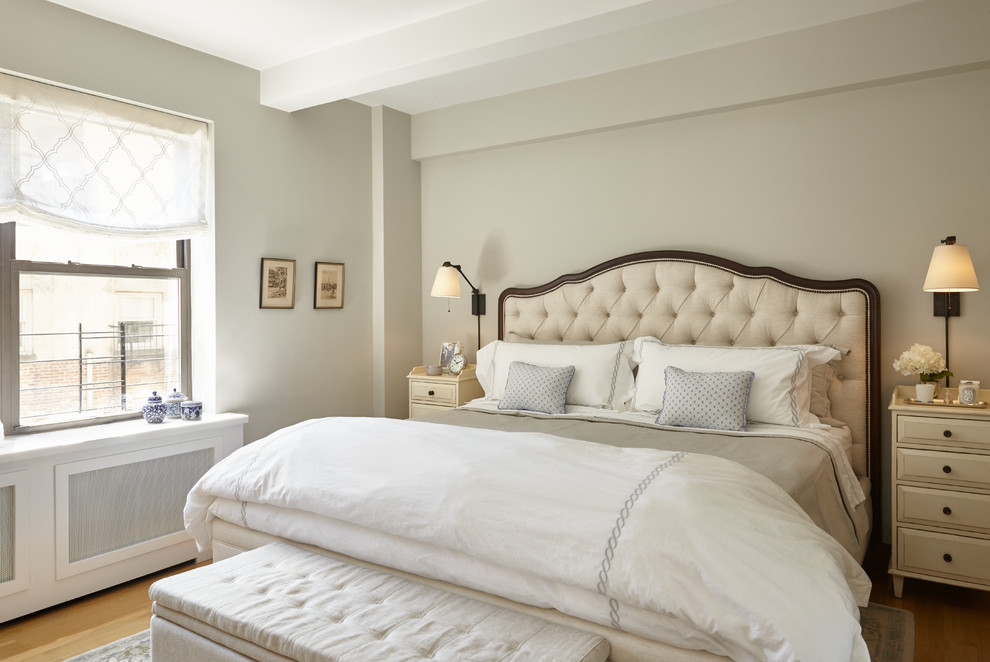 Modelo de dormitorio principal clásico renovado grande sin chimenea con suelo de madera clara y paredes grises
