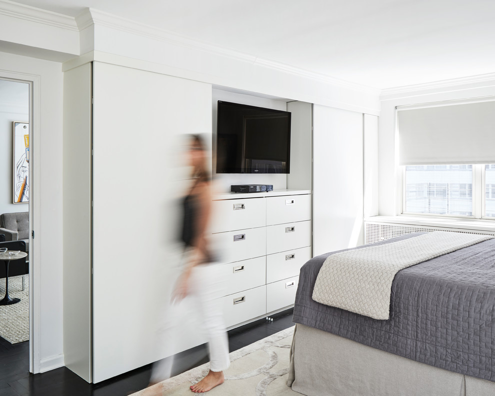 На фото: хозяйская спальня среднего размера в стиле модернизм с белыми стенами, темным паркетным полом и черным полом