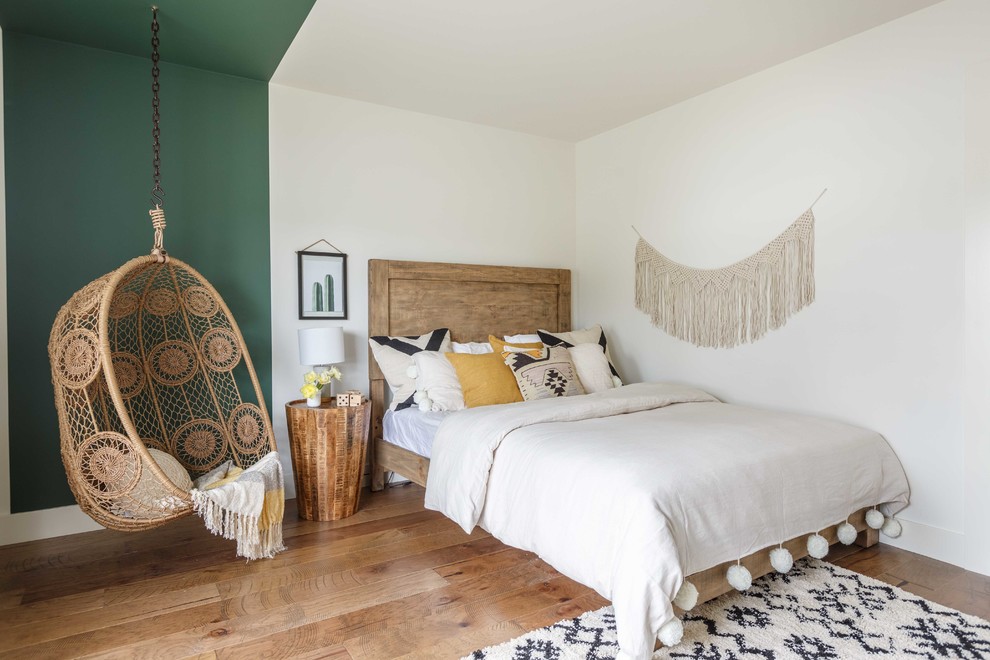 Foto de habitación de invitados contemporánea grande sin chimenea con paredes blancas, suelo de madera en tonos medios y suelo marrón