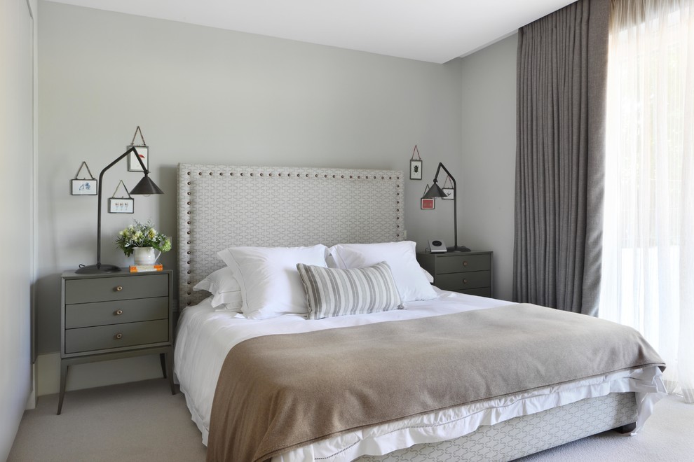 Example of a transitional guest carpeted bedroom design in London with gray walls and no fireplace