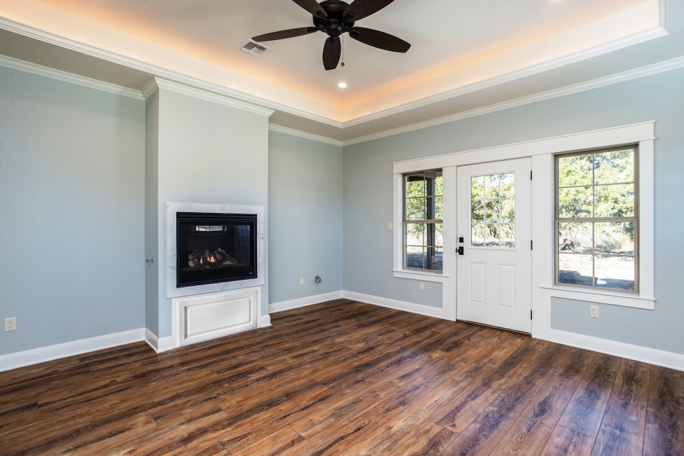 Exemple d'une chambre parentale de taille moyenne avec un mur bleu, un sol en vinyl, une cheminée standard, un manteau de cheminée en carrelage et un sol marron.