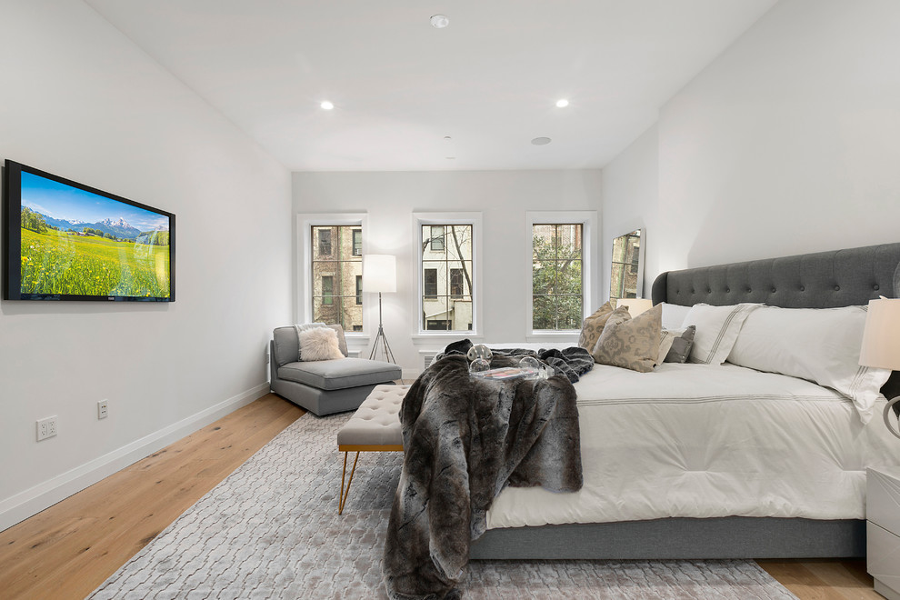 Large transitional master light wood floor and brown floor bedroom photo in New York with gray walls and no fireplace