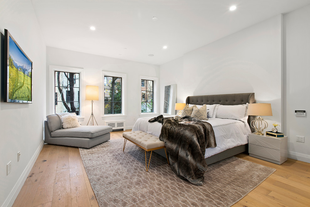 Design ideas for a large classic master and grey and brown bedroom in New York with grey walls, light hardwood flooring, no fireplace, brown floors and feature lighting.