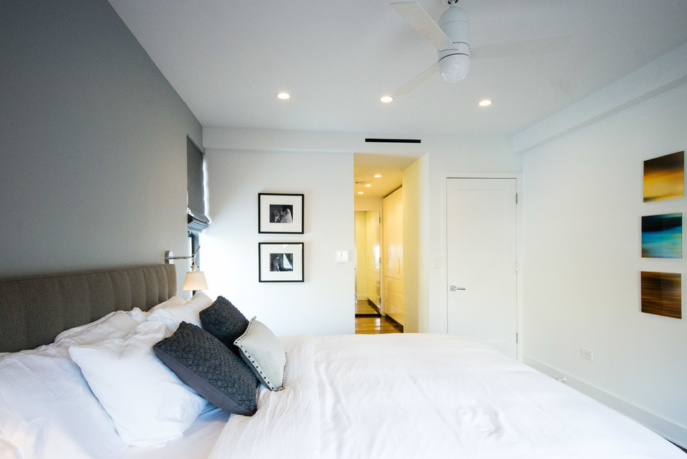Foto di un'ampia camera matrimoniale minimal con pareti bianche e pavimento in legno massello medio
