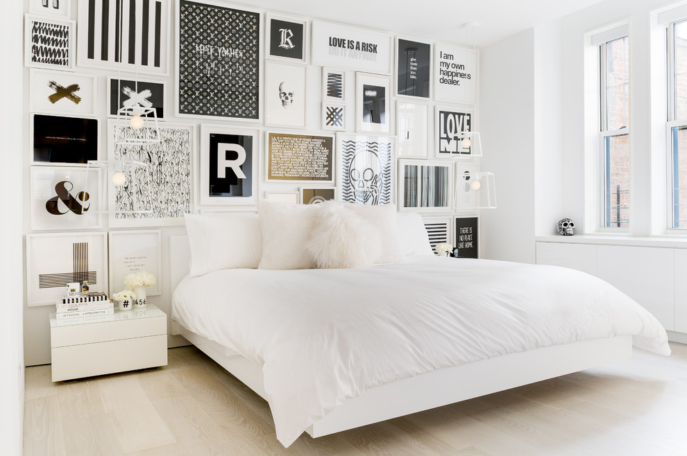 Example of a trendy light wood floor and beige floor bedroom design in New York with white walls