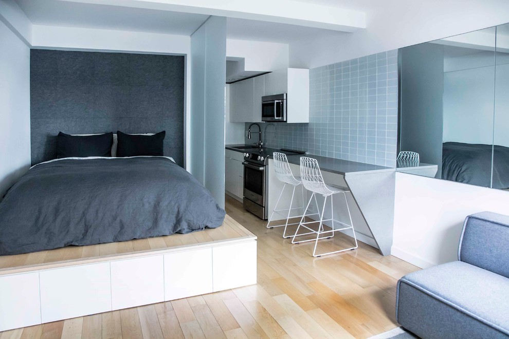 Inspiration for a contemporary bedroom in New York with grey walls and light hardwood flooring.