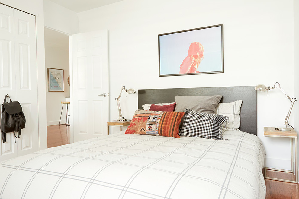 Imagen de dormitorio actual de tamaño medio con paredes blancas y suelo de madera clara