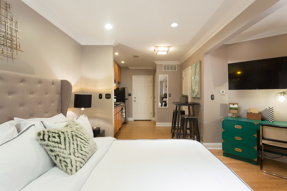 Foto di una camera da letto design di medie dimensioni con pareti grigie, pavimento in legno massello medio e nessun camino