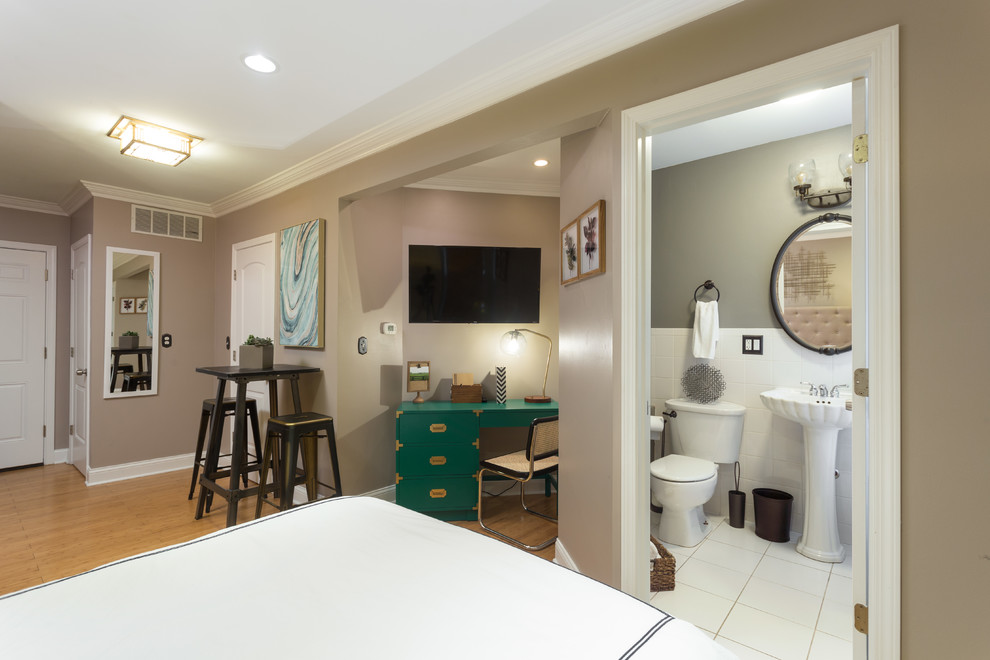 Imagen de dormitorio actual de tamaño medio sin chimenea con paredes grises y suelo de madera en tonos medios