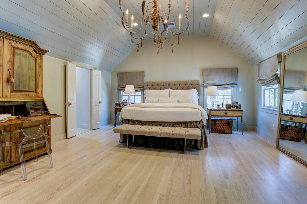 Country Hauptschlafzimmer mit hellem Holzboden in Houston