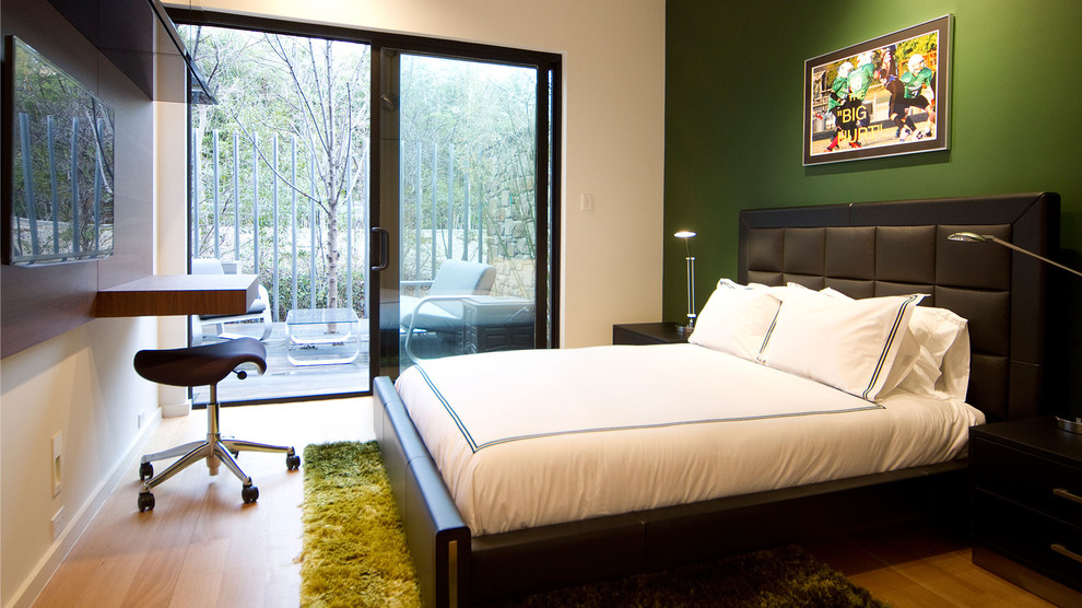Exemple d'une grande chambre moderne avec un mur vert, parquet clair et aucune cheminée.
