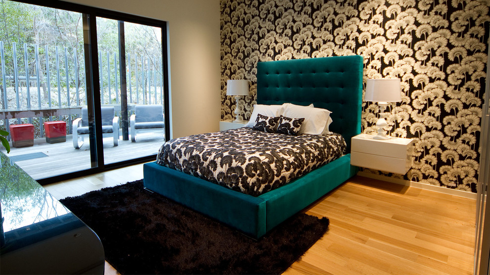 Diseño de dormitorio principal moderno grande sin chimenea con paredes blancas y suelo de madera clara