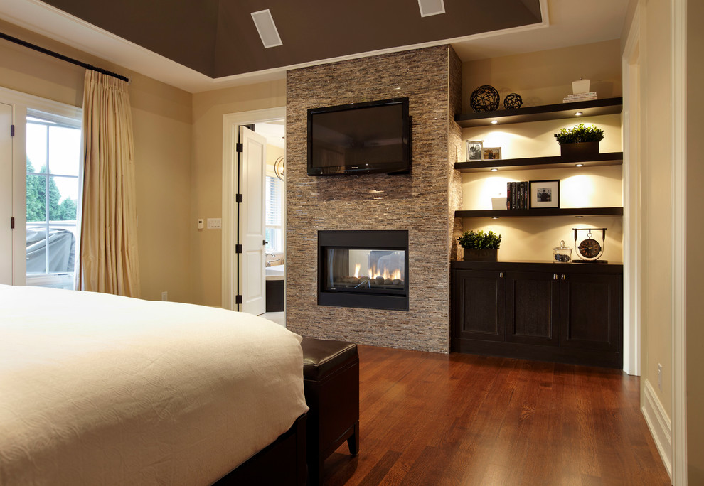 トロントにある広いコンテンポラリースタイルのおしゃれな主寝室 (ベージュの壁、無垢フローリング、両方向型暖炉、石材の暖炉まわり) のレイアウト