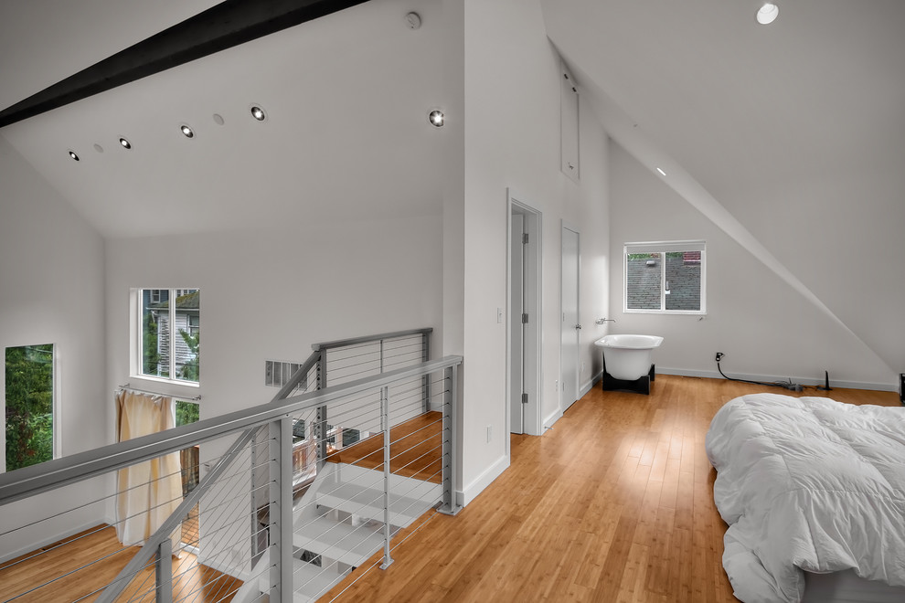 Modernes Schlafzimmer im Loft-Style mit weißer Wandfarbe und braunem Holzboden in Seattle
