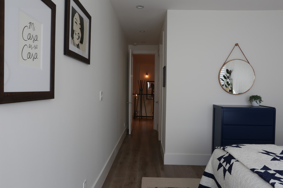 Imagen de habitación de invitados tradicional renovada de tamaño medio sin chimenea con paredes blancas, suelo de madera en tonos medios y suelo marrón
