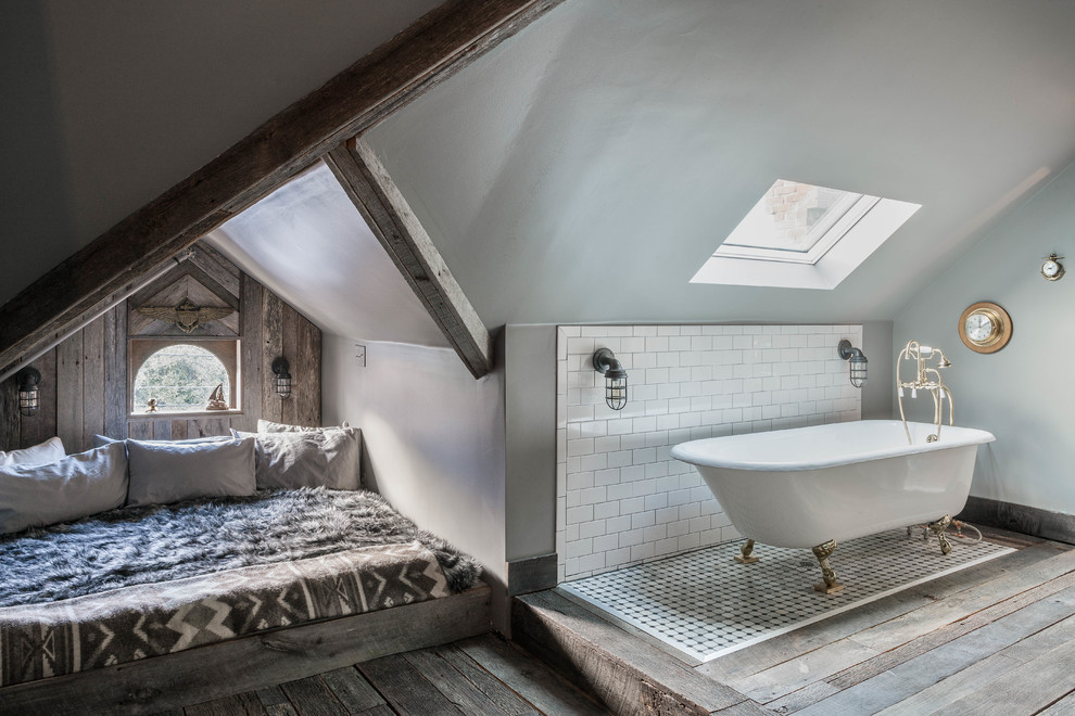 На фото: спальня на мансарде в стиле рустика с серыми стенами и темным паркетным полом