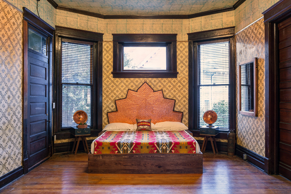 Imagen de dormitorio de estilo americano con paredes multicolor y suelo de madera oscura