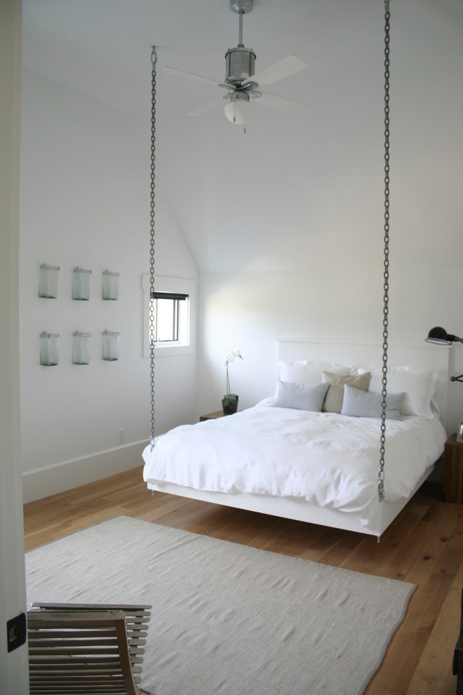 Aménagement d'une chambre campagne avec un mur blanc et un sol en bois brun.