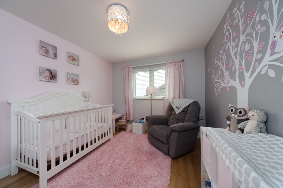 Свежая идея для дизайна: комната для малыша среднего размера в стиле неоклассика (современная классика) с розовыми стенами и светлым паркетным полом - отличное фото интерьера