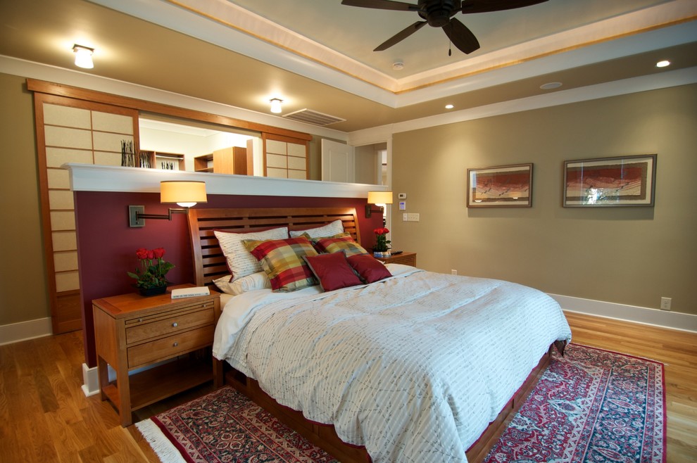 Inspiration for a contemporary bedroom in Raleigh with medium hardwood flooring and a feature wall.