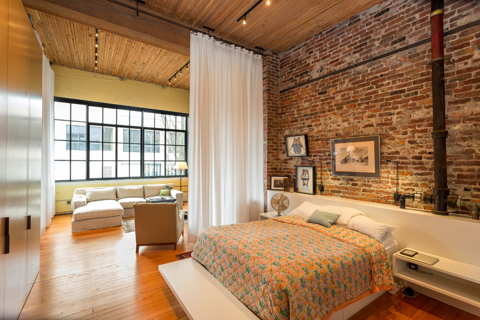 Example of a large urban medium tone wood floor bedroom design in Seattle with no fireplace