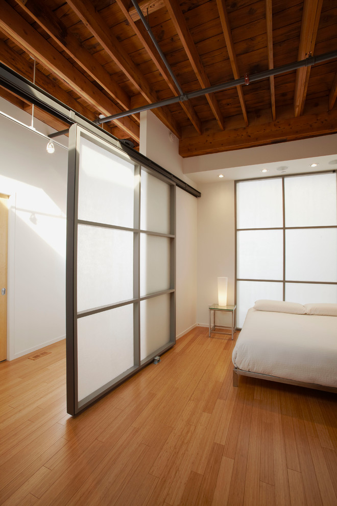 Industrial Schlafzimmer mit weißer Wandfarbe und Bambusparkett in Chicago