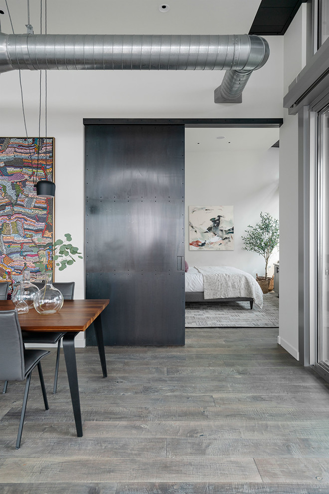 Mittelgroßes Industrial Hauptschlafzimmer mit grauer Wandfarbe, braunem Holzboden und grauem Boden in Seattle