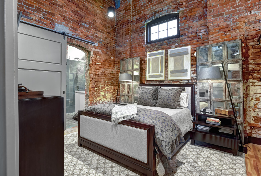 Industrial Hauptschlafzimmer ohne Kamin mit roter Wandfarbe und braunem Holzboden in Charleston
