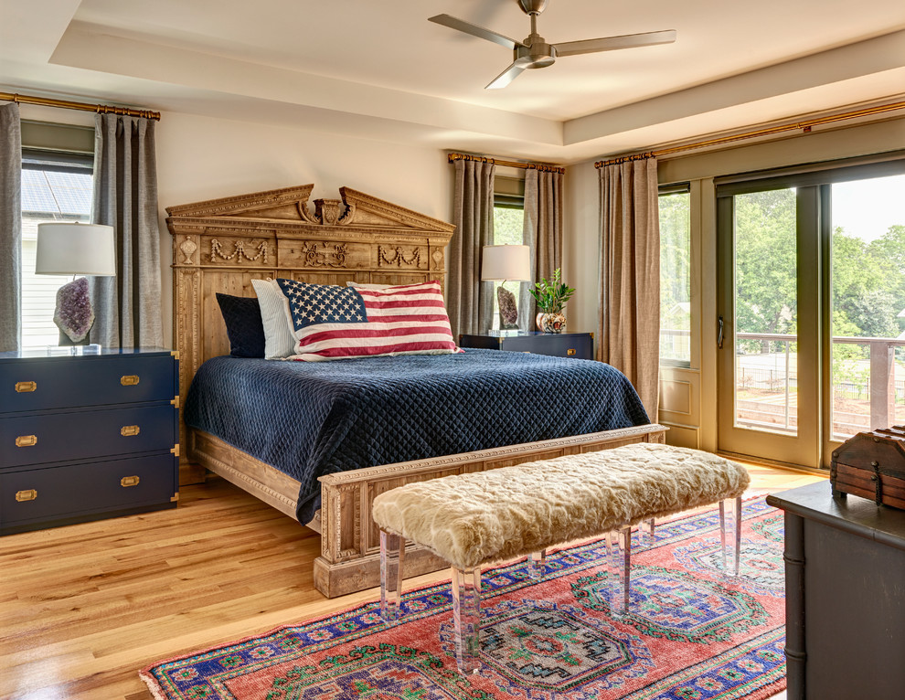 Design ideas for a large traditional master bedroom in Charlotte with light hardwood flooring.