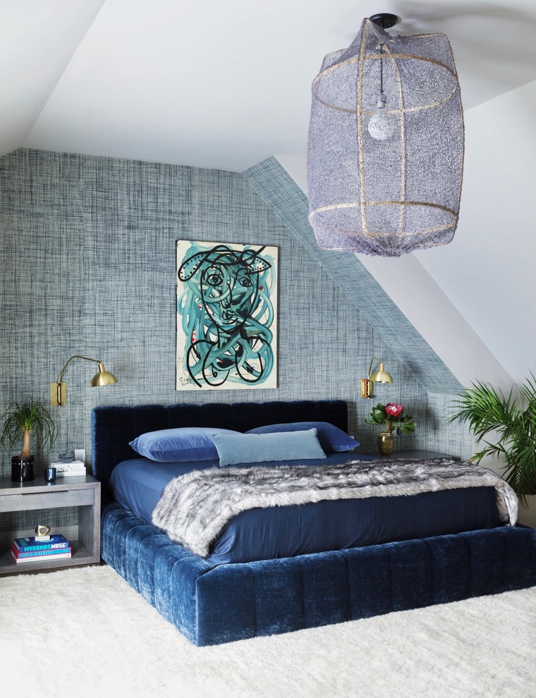 This is an example of a large eclectic master bedroom in New York with blue walls.
