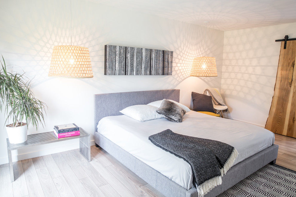 Inspiration pour une chambre parentale minimaliste de taille moyenne avec un mur blanc et un sol en bois brun.