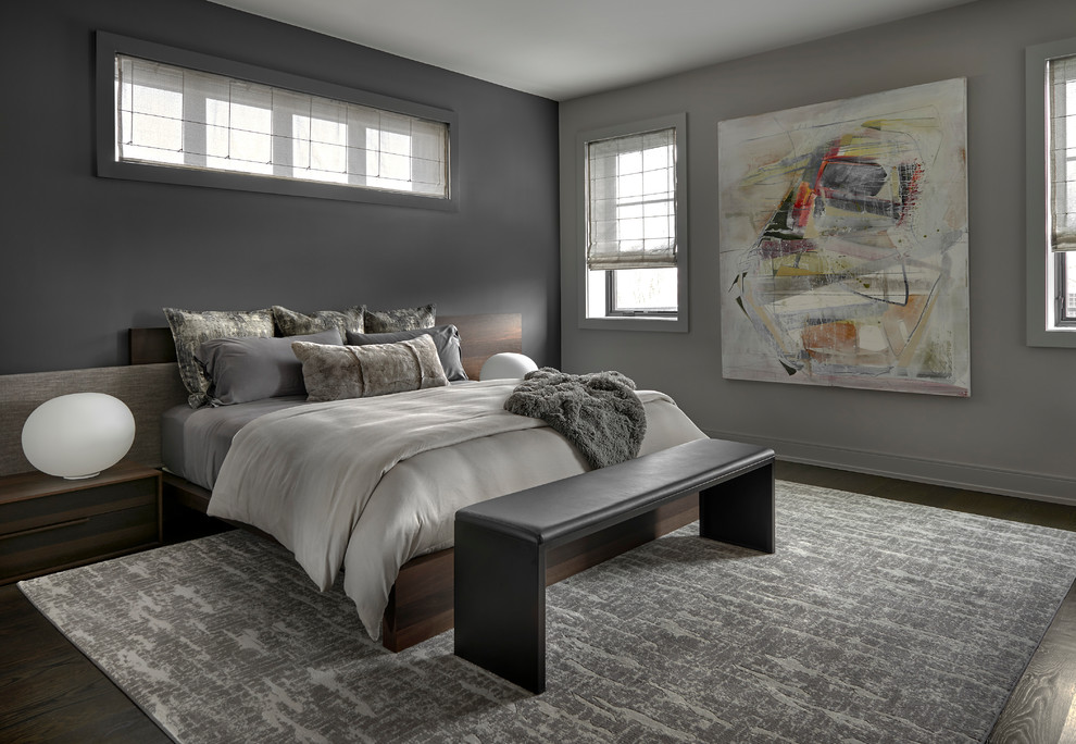 Modelo de dormitorio principal actual de tamaño medio con paredes grises, suelo de madera oscura y suelo marrón