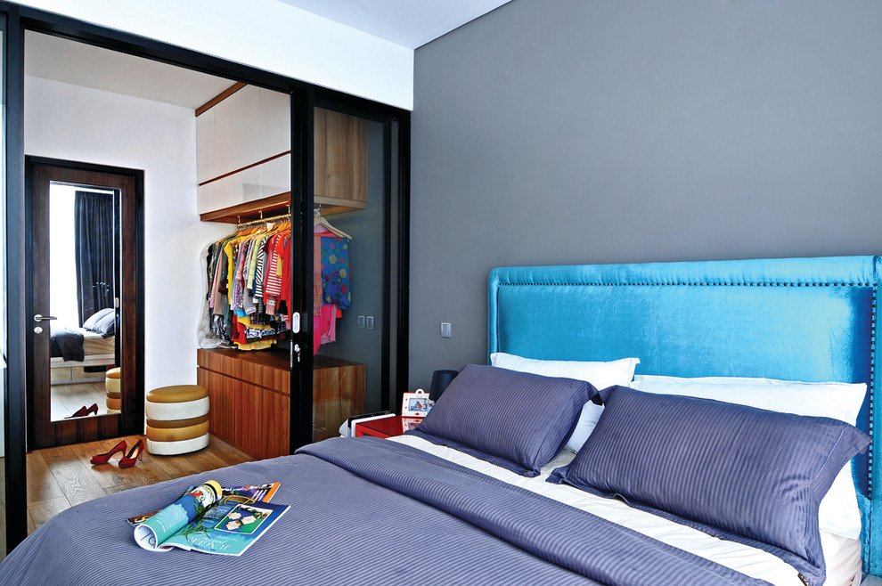 Modelo de dormitorio principal contemporáneo de tamaño medio con paredes blancas y suelo de madera clara