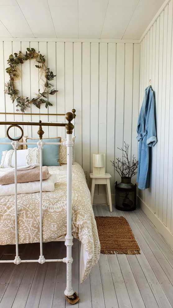 Inspiration for a country bedroom with light hardwood flooring, beige walls, grey floors and tongue and groove walls.