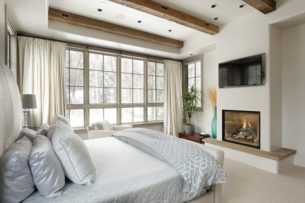 Idées déco pour une chambre contemporaine de taille moyenne avec un mur beige, une cheminée standard et un sol beige.